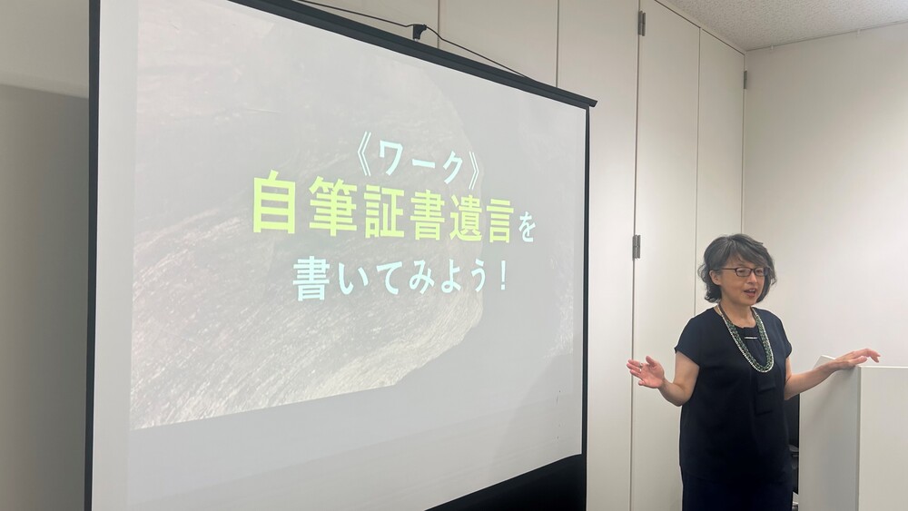スクリーンの前に立つ講師