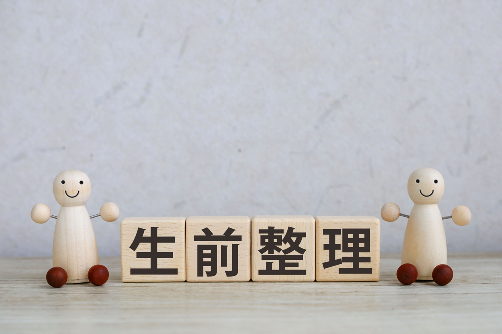 2つの人形と生前整理の文字が書かれたブロック